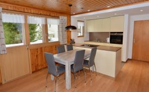 - une cuisine avec une table à manger et des chaises dans l'établissement Apartment Alouette Riederalp, à Riederalp