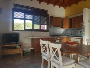 a kitchen with a table and chairs and a television at Villa Eos in Gaios