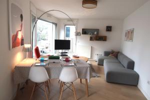 ein Wohnzimmer mit einem Tisch und einem Sofa in der Unterkunft Chambre d'hôte Naos Homestay in Boulogne-Billancourt