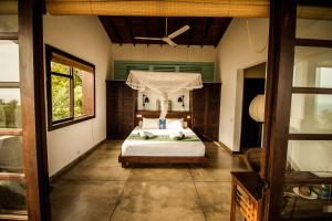 a bedroom with a bed with a canopy at Little Tamarind in Tangalle