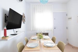 une salle à manger avec une table, des chaises et une télévision à écran plat dans l'établissement Villa Julia, à Riumar