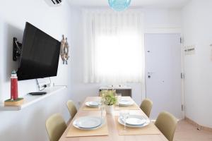 a dining room with a table with chairs and a flat screen tv at Villa Julia in Riumar