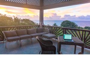 un portico con divano e tavolo con computer portatile di Little Tamarind a Tangalle