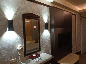 Baño con 2 luces en la pared y espejo en Xin Yuan Motel en Taichung