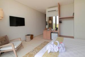 um quarto de hotel com uma cama com toalhas em Svarga Resort Lombok em Senggigi
