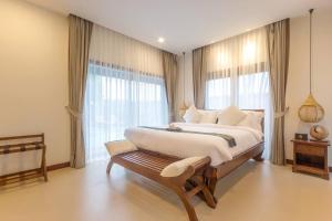 a bedroom with a large bed and a large window at Ozone Villa Phuket in Ban Pa Khlok