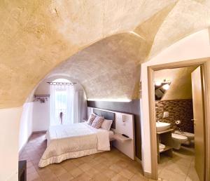 a hotel room with a bed and a mirror at Il Sorriso Dei Sassi Rooms in Matera