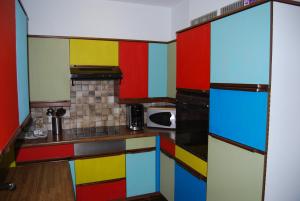 a colorful kitchen with colorful cabinets at Ruzettelaan 183 T11 bus 192 in Blankenberge