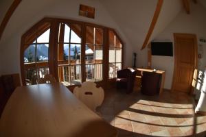 Zimmer mit einem Holztisch und einem großen Fenster in der Unterkunft Appartement Gafluna in Sankt Anton am Arlberg