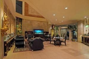 a lobby with chairs and a television and a table at Hotel Indah Palace Solo in Solo
