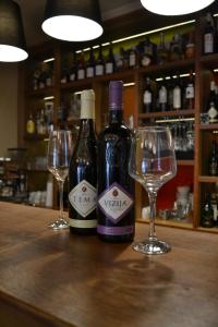 two bottles of wine and two glasses on a bar at B&B Villa Panuka in Pančevo