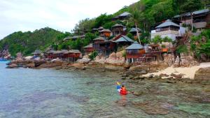 a person in the water in front of a resort at Taatoh Seaview Resort - SHA Plus in Koh Tao
