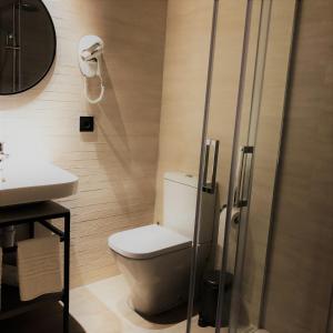 a bathroom with a toilet and a sink and a shower at HOTEL TORRENT in L'Escala