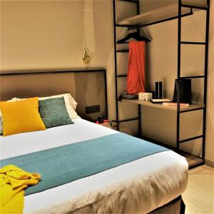 a bedroom with a large bed with colorful pillows at HOTEL TORRENT in L'Escala
