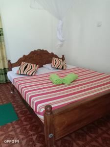 a bed with two green towels on top of it at Jungle House Tourist Inn in Dambulla