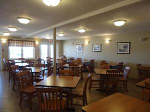 comedor con mesas y sillas de madera en Auberge Bouctouche Inn & Suites, en Bouctouche