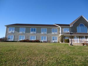 a large house with a lawn in front of it at Auberge Bouctouche Inn & Suites in Bouctouche