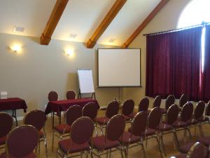 una sala de conferencias con sillas y una pantalla en Auberge Bouctouche Inn & Suites, en Bouctouche