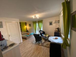 uma sala de estar com uma cozinha e um quarto com uma sala de estar em Maison Carmen - Restaurant , meublé de tourisme, appartements em Xertigny