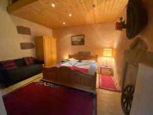 1 dormitorio con 1 cama y 1 sofá en una habitación en Maison Carmen - Restaurant , meublé de tourisme, appartements, en Xertigny