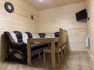 Zimmer mit Sofa, Tisch und Uhr in der Unterkunft Forsage Hostel in Uschhorod