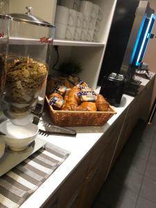 una nevera llena de pan y una cesta de bollería en Auberge de la Gravière, en Orcières