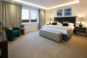 a bedroom with a bed and a couch and a chair at Cheval Gloucester Park at Kensington in London