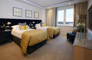 a hotel room with two beds and a window at Cheval Gloucester Park at Kensington in London