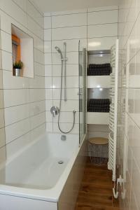 a white bathroom with a tub and a shower at HT Chalets Harrachov in Harrachov