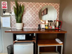 a counter with a sink and a mirror on a wall at Patuxay Place in Vientiane
