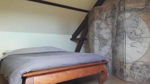 a bedroom with a bed with a map on the wall at La Maison de l'Isle in Eu