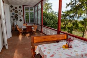 a screened in porch with a table and chairs at Villa Tabody in Révfülöp