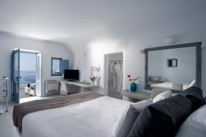 a bedroom with a large bed and a living room at Pegasus Villas in Imerovigli +59 photos