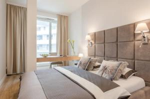 a bedroom with a large bed and a desk at Ovo Apartment Market Square Wroclaw in Wrocław