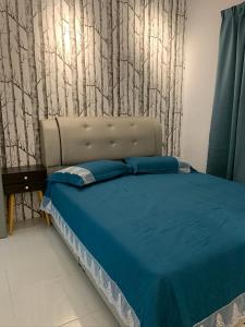 1 dormitorio con 1 cama con sábanas azules y árboles en la pared en Garden Sky Homestay en Melaka