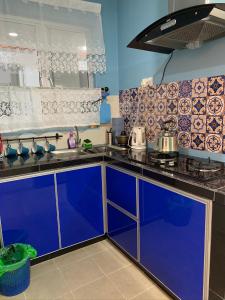 una cocina con armarios azules y fregadero en Garden Sky Homestay en Melaka