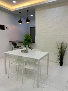 una mesa blanca y sillas en una habitación en Garden Sky Homestay en Melaka