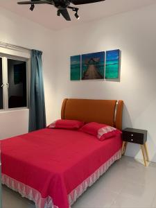 1 dormitorio con 1 cama con colcha roja en Garden Sky Homestay en Melaka