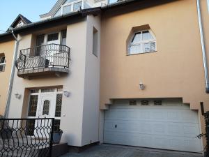a house with two balconies and a garage at Hotello Apartmanház és Panzió in Zalaegerszeg