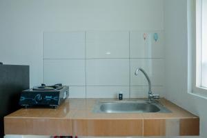 a kitchen with a sink and a toaster on a counter at Cozy Studio Apartment at Margonda Residence 4 By Travelio in Depok +5 photos
