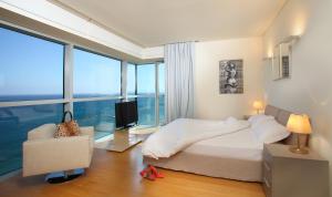 a bedroom with a bed and a large window at Olympic Residence Deluxe Apartments in Limassol