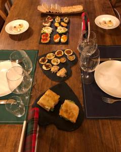 una mesa con platos de comida y copas de vino en Cascina La Maddalena Bed & Wine, en Rocca Grimalda