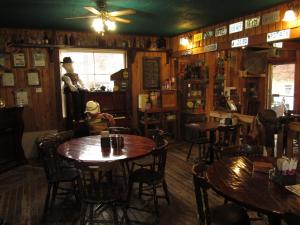 a restaurant with wooden tables and chairs in a room at Old Towne Inne Chuckwagon Bar & Grill in Boston Bar