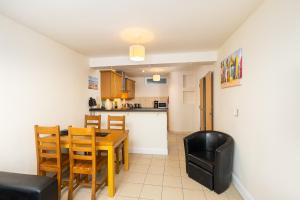 a kitchen and dining room with a table and chairs at West Beach - Holiday Apartments in Westward Ho