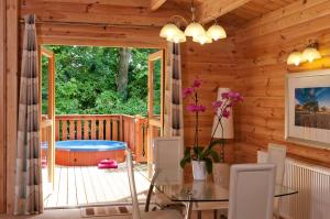 a dining room with a deck with a hot tub at South Winchester Lodges in Winchester