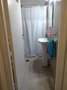 a bathroom with a white shower curtain and a sink at VILLA VIDA - No se aceptan grupos de jóvenes in Mar del Plata