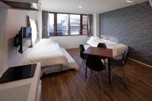 a bedroom with a bed and a desk and a table at Hotel Litlle Bird OKU-ASAKUSA in Tokyo