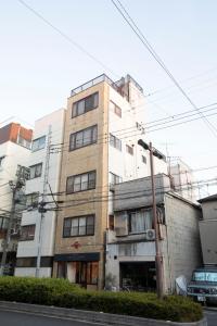 a tall building with many windows next to a street at Hotel Litlle Bird OKU-ASAKUSA in Tokyo