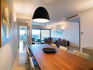 a dining room and living room with a table and chairs at Olympic Residence Deluxe Apartments in Limassol