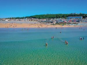 eine Gruppe von Menschen im Wasser an einem Strand in der Unterkunft The Waterfront Inn in Westward Ho